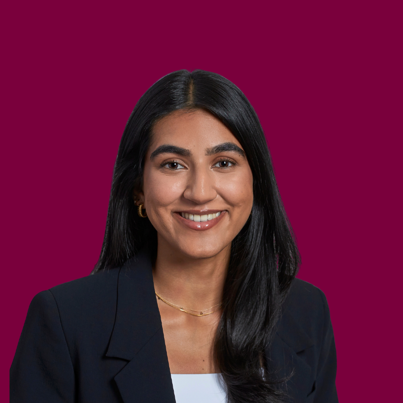 Headshot of Serena Sandhu, a smiling woman with long dark hair and a dark blazer.